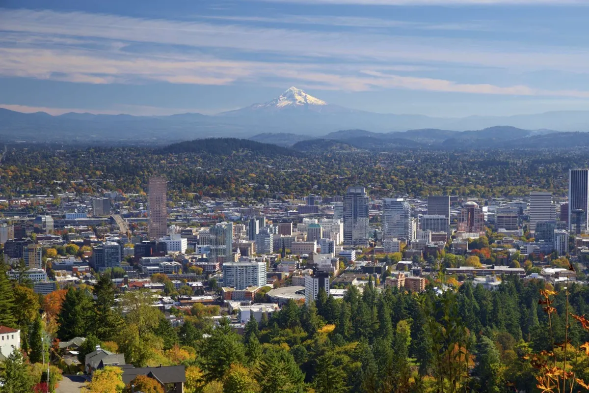 This image features a breathtaking view of Portland’s city skyline with Mount Hood in the background, framed by autumn foliage. The expansive scene captures the spirit of exploration and the beauty of Portland’s natural surroundings.